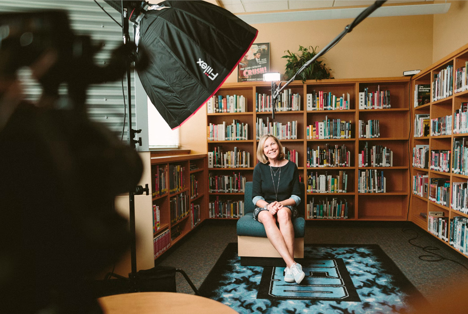Mujer en la biblioteca de su casa haciendo una entrevista